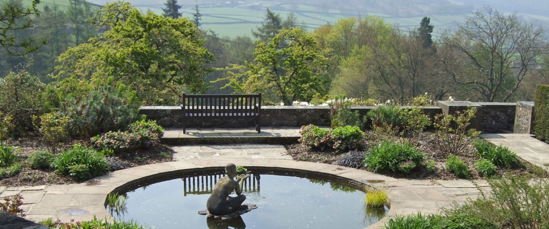 A geometric garden with a central circular pond looks out over a Yorkshire landscape.