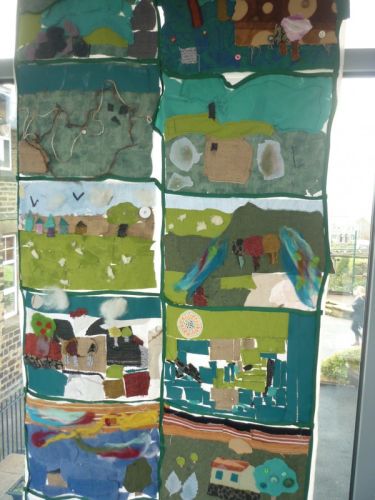 A colourful textile wall hangings of greens and blues depicting landscapes.