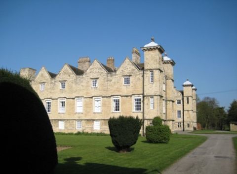 Ledston Hall view of house and yew topiary on grassed lawn to the side