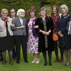 A group of people stand together in a garden.